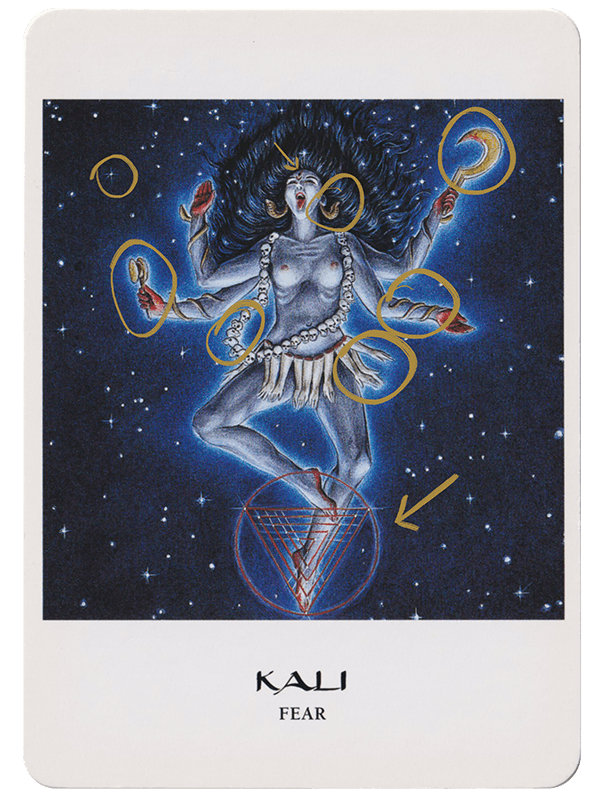 The Goddess Oracle Card by Amy Sophia Marashinsky features an illustrated Kali dancing in space with a belt of skulls and belt of severed arms. The card has the words Kali and Fear written on it and yellow drawn circles over card clues.