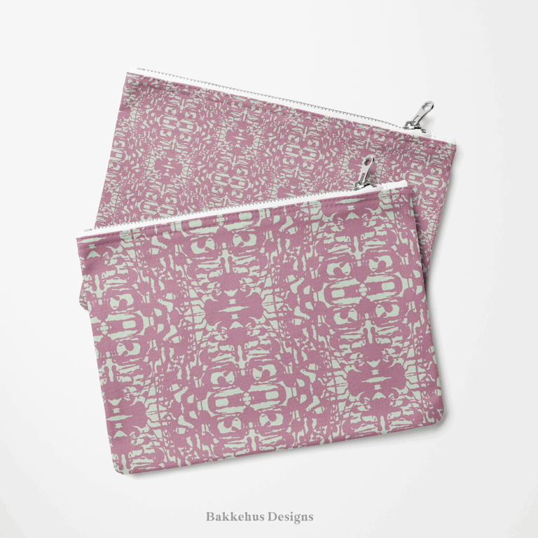 Two zip pouches made from Abstract Inked Lace fabric, one lying on the other, printed with a pale sage green lace pattern on dusty mauve.