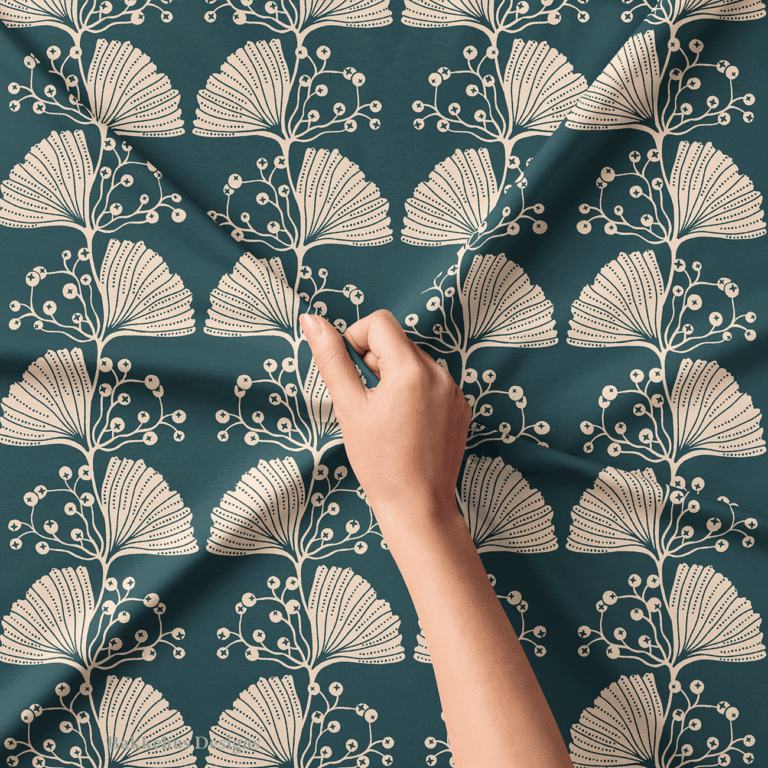Close-up of a hand lifting Art Nouveau Ginkgo Sprig fabric, showing the fine line work and dotted cut-outs on the cream ginkgo leaves and berry sprigs against deep teal.