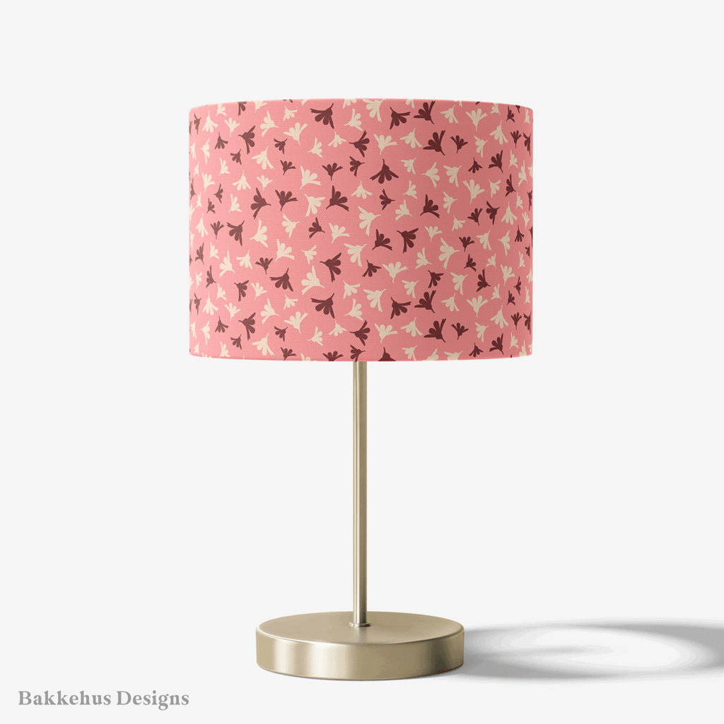 Table lamp with a brass stand and a round drum shade covered in Ditsy Flower Sprigs, rosewood and cream flower sprigs on soft pink.