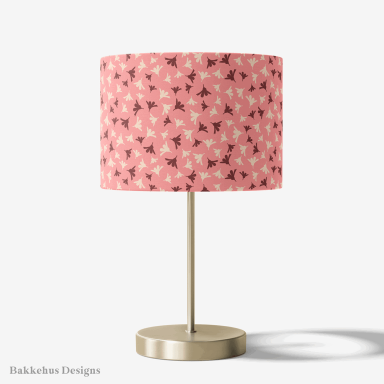 Table lamp with a brass stand and a round drum shade covered in Ditsy Flower Sprigs, rosewood and cream flower sprigs on soft pink.