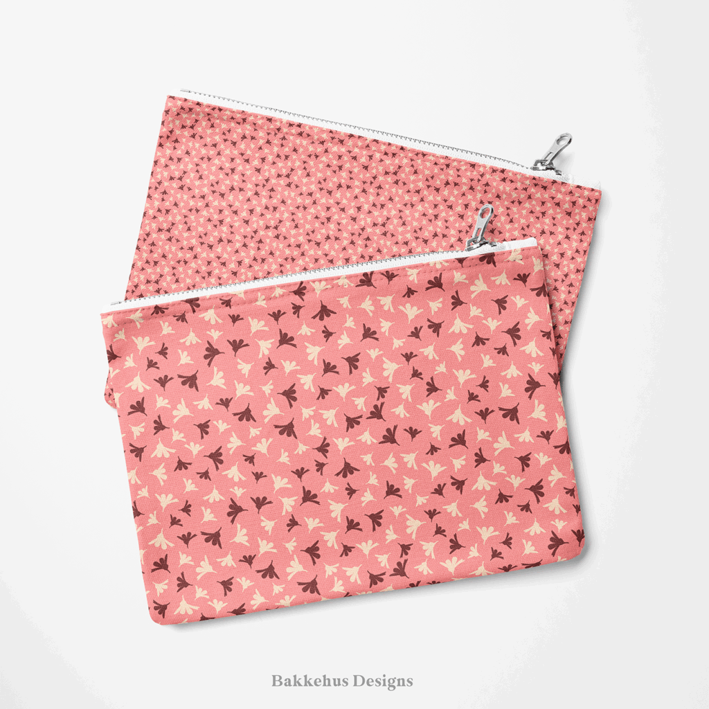 Two zip pouches made from Ditsy Flower Sprigs fabric, one lying on the other, printed with tiny rosewood and cream flower sprigs on soft pink.