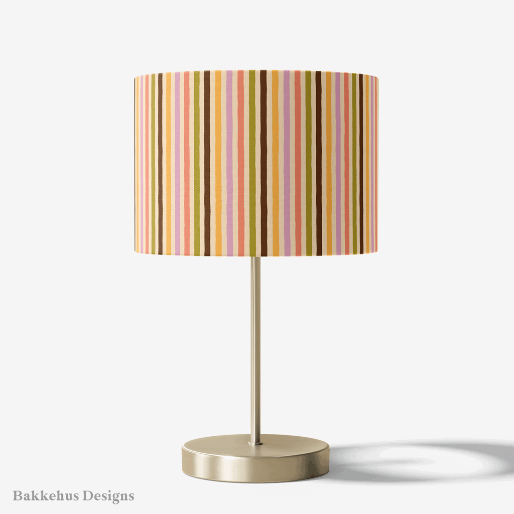 Table lamp with a brass stand and a round drum shade covered in Organic Narrow Stripe, a hand drawn stripe in earthy retro colours.