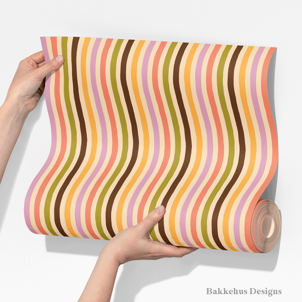 Two hands unroll a length of Organic Narrow Stripe wallpaper, showing the hand drawn vertical stripes in earthy retro colours.