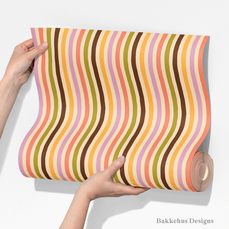 Two hands unroll a length of Organic Narrow Stripe wallpaper, showing the hand drawn vertical stripes in earthy retro colours.