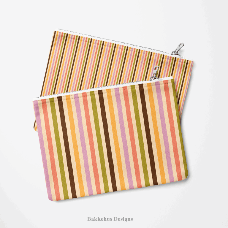 Two zip pouches made from Organic Narrow Stripe fabric, one lying on the other, printed with narrow hand drawn stripes in earthy retro colours.
