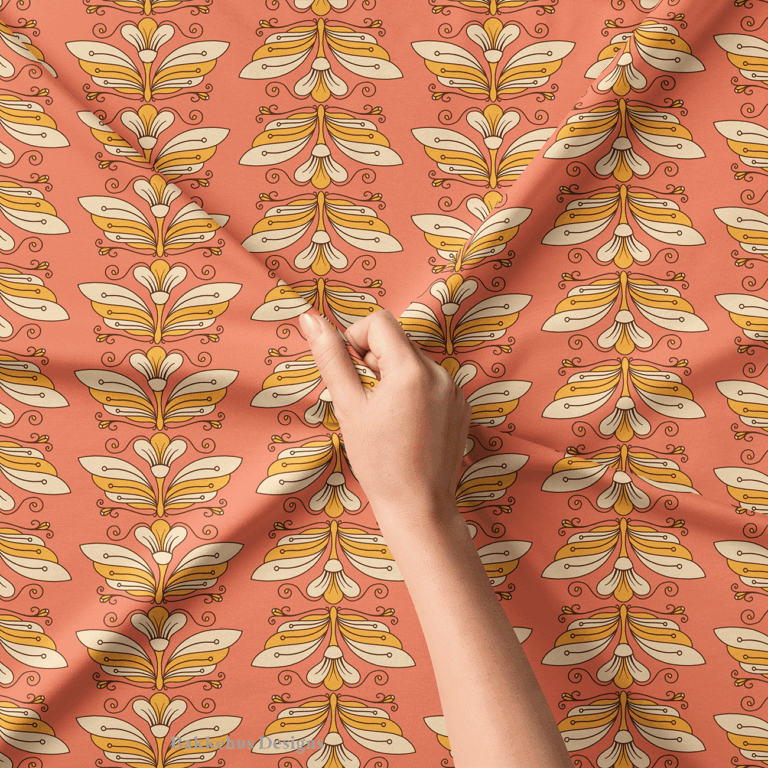 Close-up of a hand lifting Retro Flower Moth Stripe fabric, showing the cream and gold flower moths stacked in columns with curling tendrils on coral.