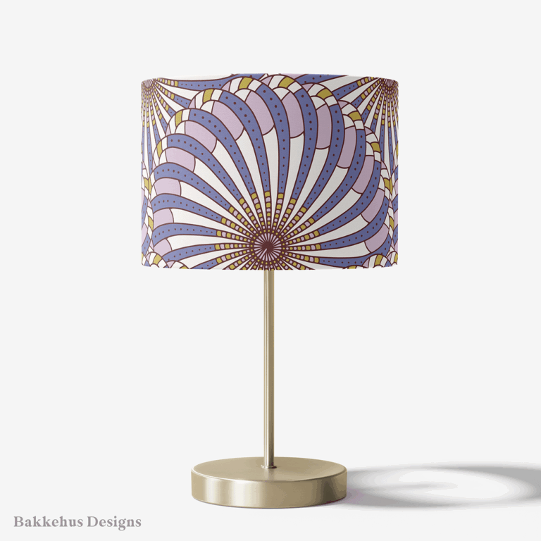 Table lamp with a brass stand and a round drum shade covered in the Retro Gatsby Disco Art Deco scallop fan pattern in cornflower blue and lilac.