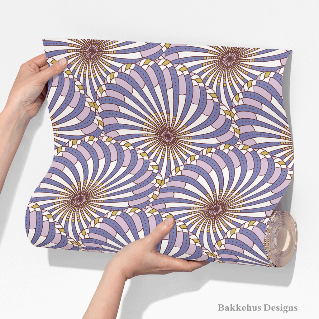 Two hands unroll a length of Retro Gatsby Disco wallpaper, showing how the large-scale cornflower blue and lilac scallop fans repeat across the width.