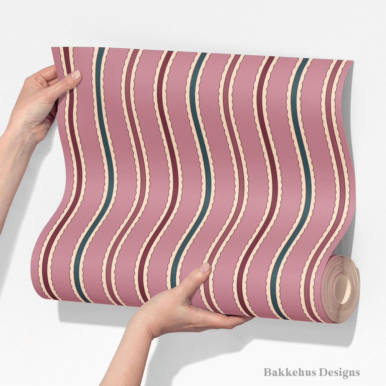 Two hands unroll a length of Scalloped Cabana Stripe wallpaper, showing vertical stripes in mauve, deep teal and burgundy with a cream scallop edge.