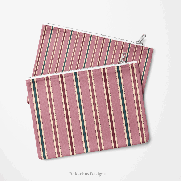 Two zip pouches made from Scalloped Cabana Stripe fabric, one lying on the other, printed with mauve, deep teal and burgundy stripes edged in cream.