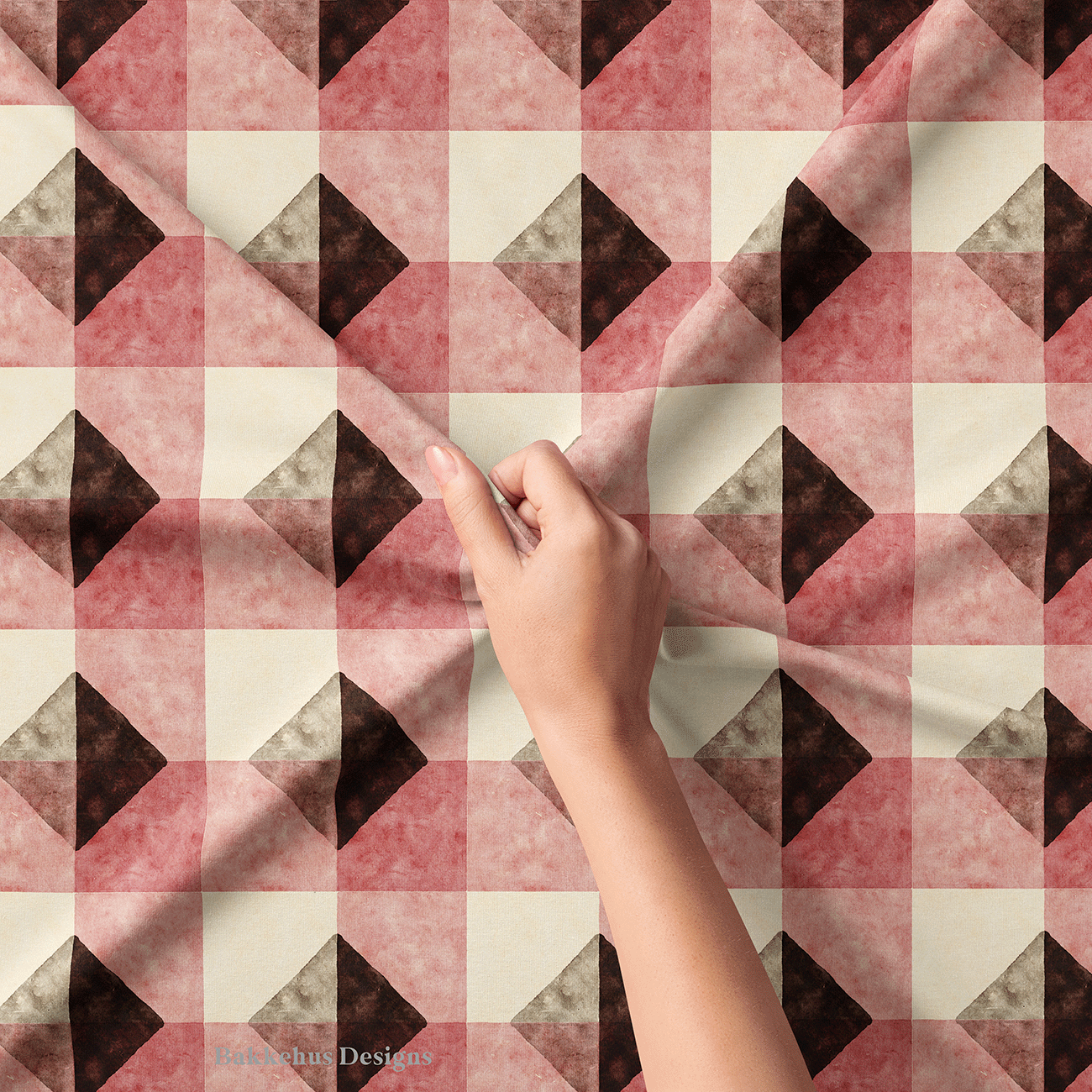 Close-up of a hand lifting Textured Brown Diamond Check fabric, showing the watercolour-style texture on the deep brown diamonds and clay-rose blocks.