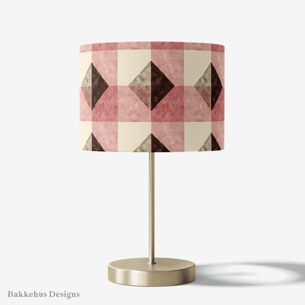 Table lamp with a brass stand and a round drum shade covered in the Textured Brown Diamond Check pattern, with deep brown diamonds and clay-rose blocks on cream.