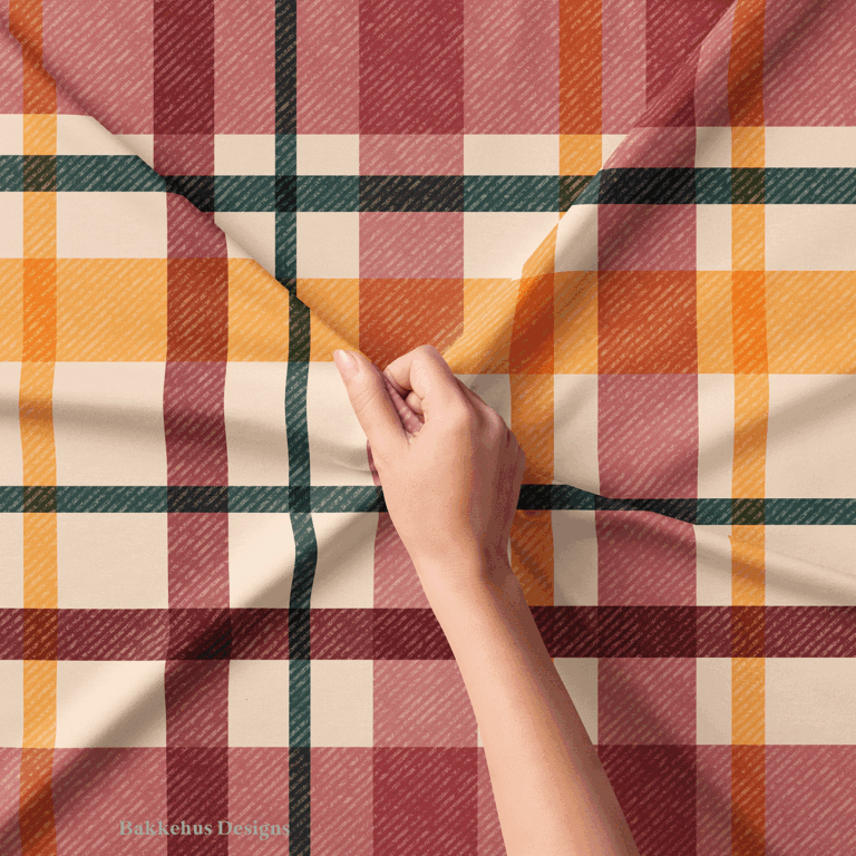 Close-up of a hand lifting Textured Windowpane Plaid fabric, showing the diagonal grain running through the teal, burgundy, mauve and burnt orange checks.
