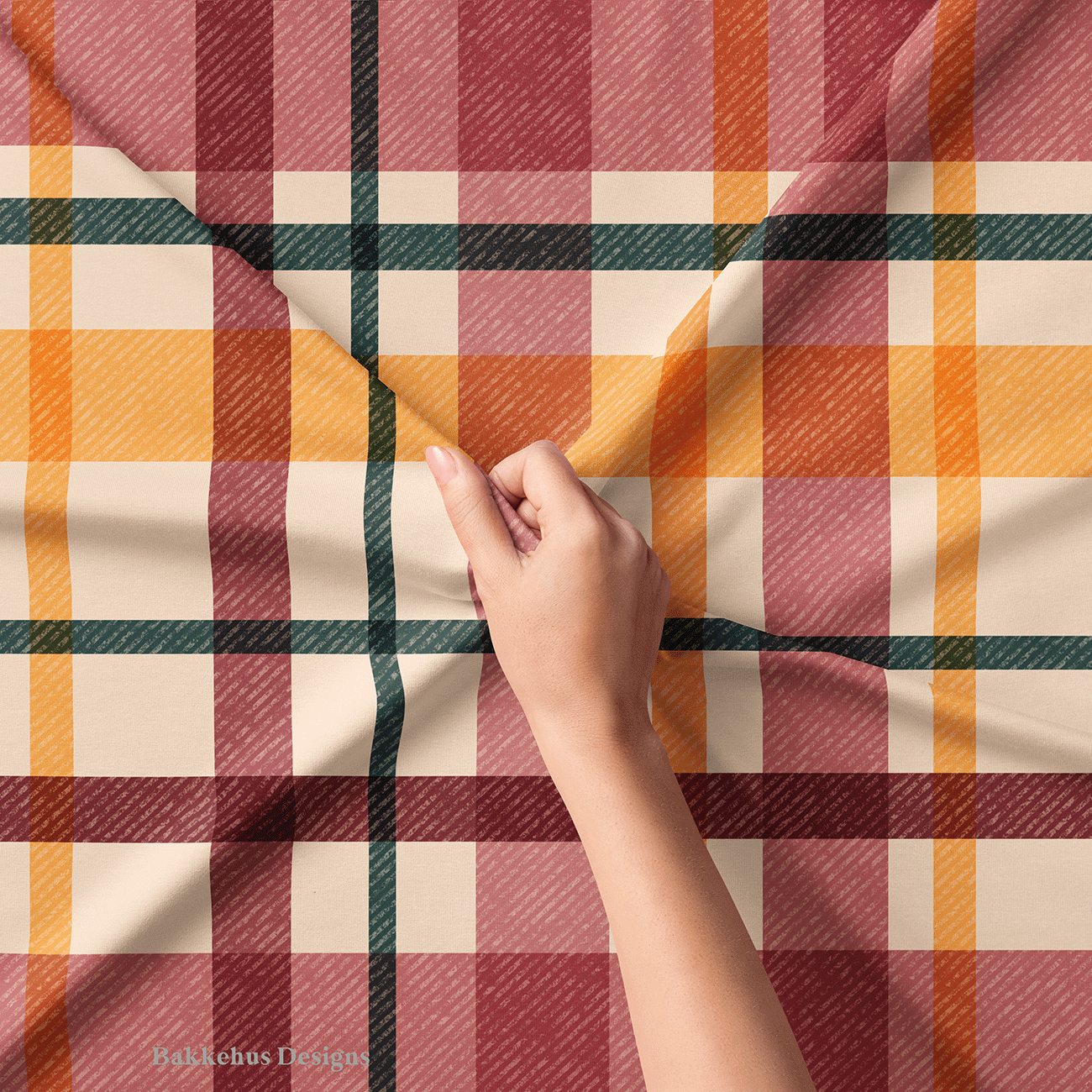 Close-up of a hand lifting Textured Windowpane Plaid fabric, showing the diagonal grain running through the teal, burgundy, mauve and burnt orange checks.