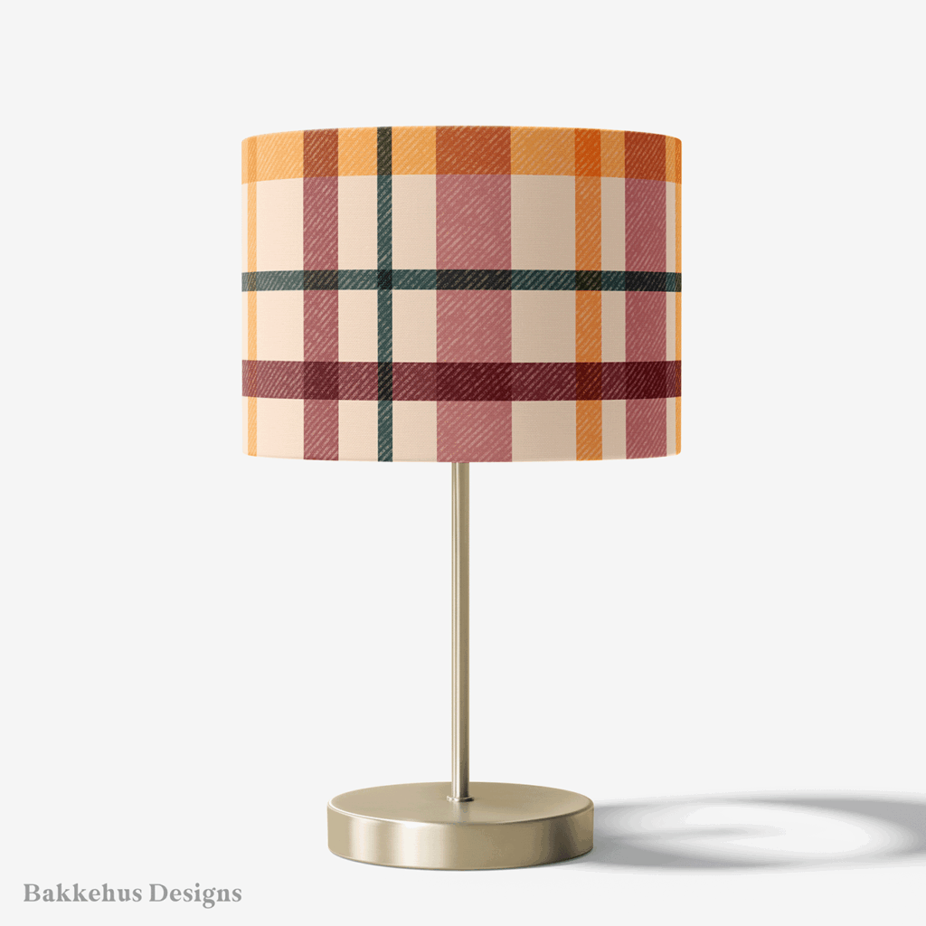 Table lamp with a brass stand and a round drum shade covered in Textured Windowpane Plaid, a retro plaid in teal, burgundy, mauve and burnt orange on beige.