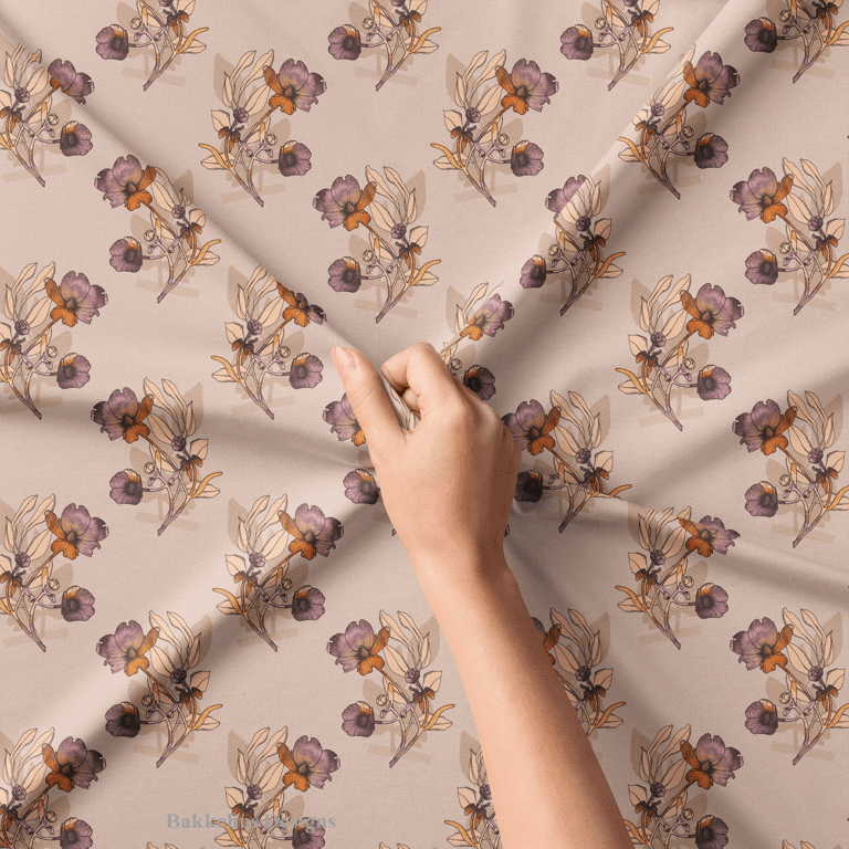 Close-up of a hand lifting Vintage Buttercup Floral fabric, showing scattered hand-drawn ranunculus sprigs in mauve, plum and rust on warm blush.