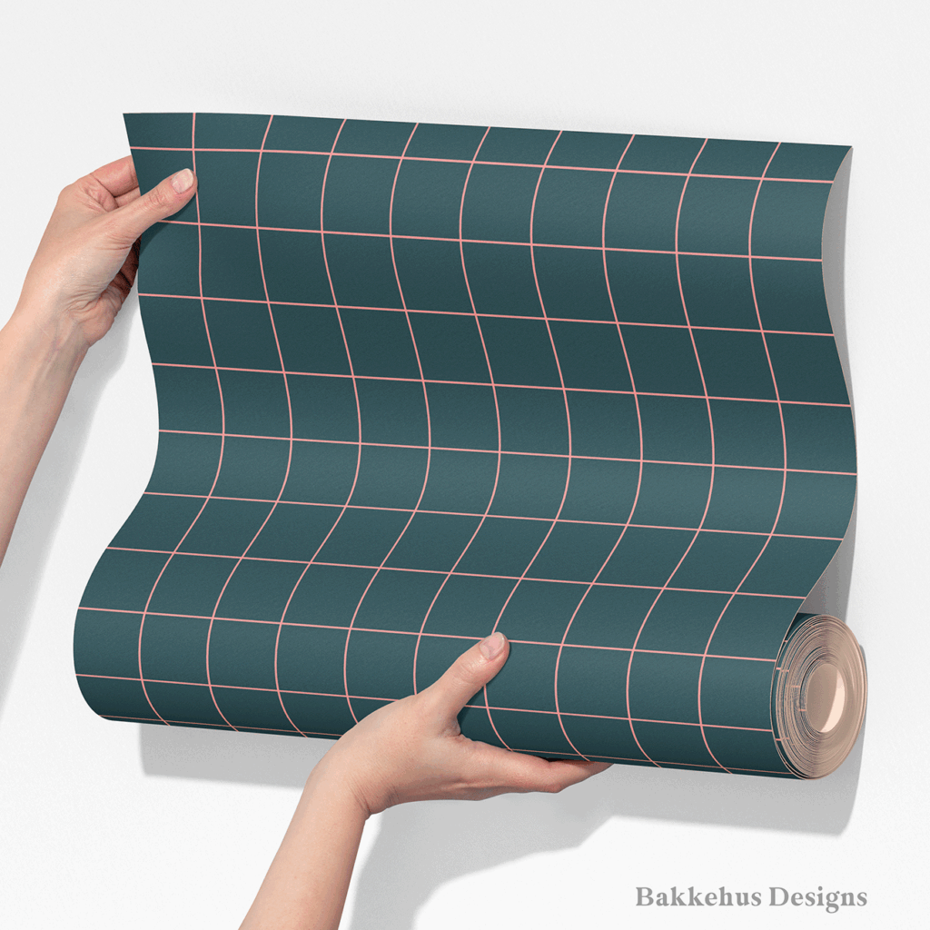 Two hands unroll a length of Windowpane Check wallpaper, showing the pink windowpane grid repeating on deep teal.